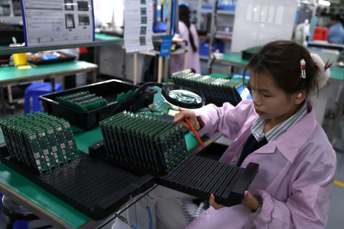 Nhân viên kiểm tra bảng mạch tại một nhà máy đối tác của Agilian Technology ở Đông Quản. Ảnh: Reuters